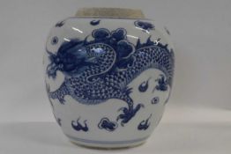 A Chinese porcelain jar with painted blue and white decoration of a dragon chasing the flaming