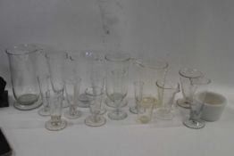 Tray containing quantity of measuring jugs for chemists etc, all with engraved calibration