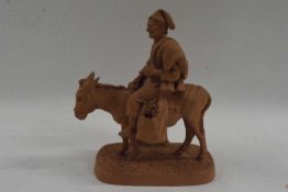 A Spanish terracotta model of a man astride a donkey, the base marked Grasso Riposto