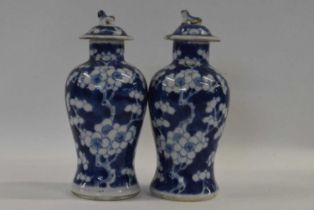 A small pair of 19th Century Chinese porcelain vases and covers, the baluster body decorated with