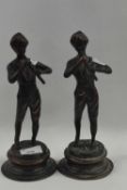 A pair of Spelter models of musicians on shaped metal bases, 26cm high