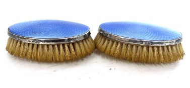 A pair of George VI silver and enamel clothes brushes of oval form having light blue guilloche