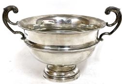 George V silver twin handled trophy cup/bowl having high scroll handles on a stepped circular