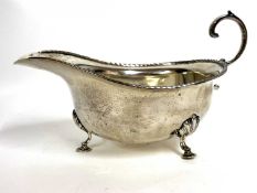 George V silver cream jug of typical form with a reeded detail border, flying cap leaf handle