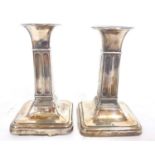 Small pair of Edwardian silver candlesticks having round capitals and square fluted colums to a