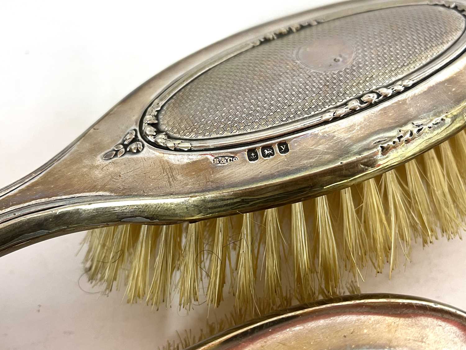 George V silver mounted cased dressing table set comprising a hand mirror, two hairbrushes and two - Image 5 of 6