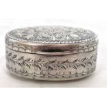 Edwardian silver snuff box of oval form, the hinged lid chased and engraved all over with scrolls