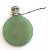 Vintage green glass scent bottle of flat circular form having an embossed gilt metal screw on top,