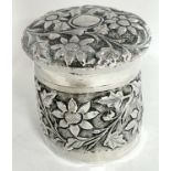Continental white metal jar and cover, heavily embossed and chased with flowers and leaves etc