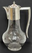 George V glass and silver mounted claret jug, the bulbous body engraved with tied ribbon and garland