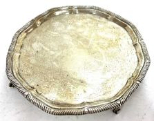 George V silver salver, the scalloped rim with gadrooned border supported on four claw and ball