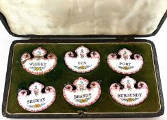 Set of six early 20th Century enamel decanter labels in fitted case (one with faults)