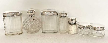 Group of silver lidded dressing table jars and scent bottle, comprising two oval faceted glass jars,
