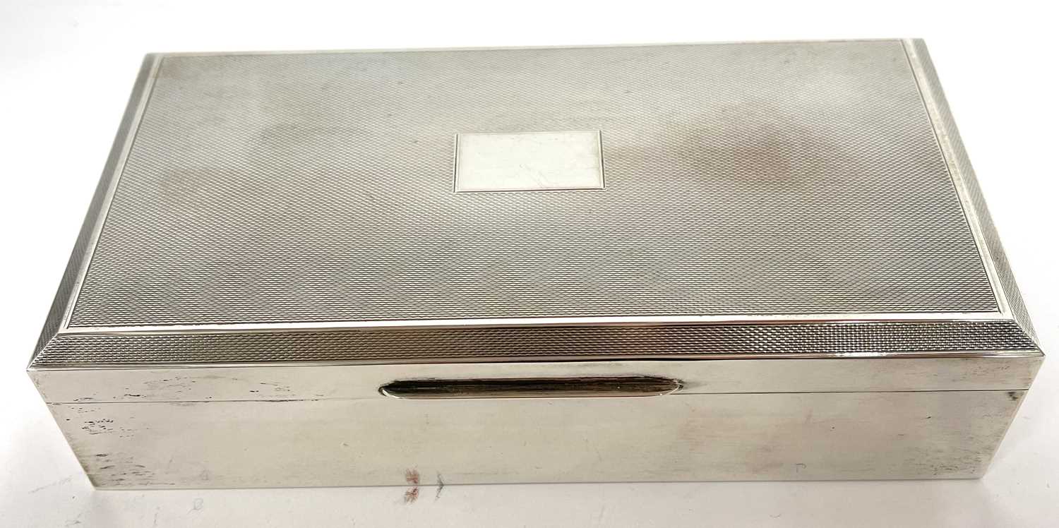 Silver cigarette box of rectangular form, the hinged lid with engine turned decoration around a