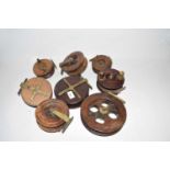 A collection of eight wooden centre pin fishing reels to include star backed examples, largest 7