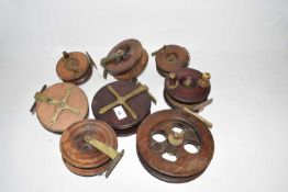 A collection of eight wooden centre pin fishing reels to include star backed examples, largest 7