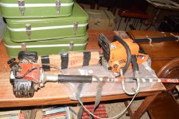 Swiss Kraft International chainsaw together with a petrol strimmer