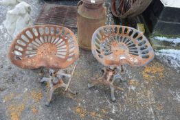 Pair of iron bar stools with tractor style seats