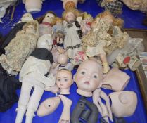 A large mixed lot of various porcelain headed dolls and various extra limbs, bodies and heads