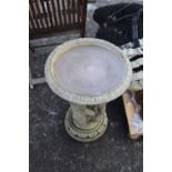 Concrete bird bath with cherub decoration