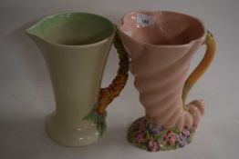 Two Clarice Cliff jugs , one of cornucopia form with floral handle and anither similiar. Largest