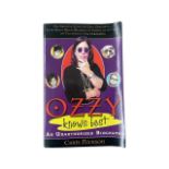 A paperback copy of Ozzy Knows Best: An Unauthorized biography of Ozzy Osbourne, front man of