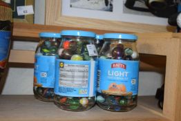 Four glass jars, assorted modern marbles