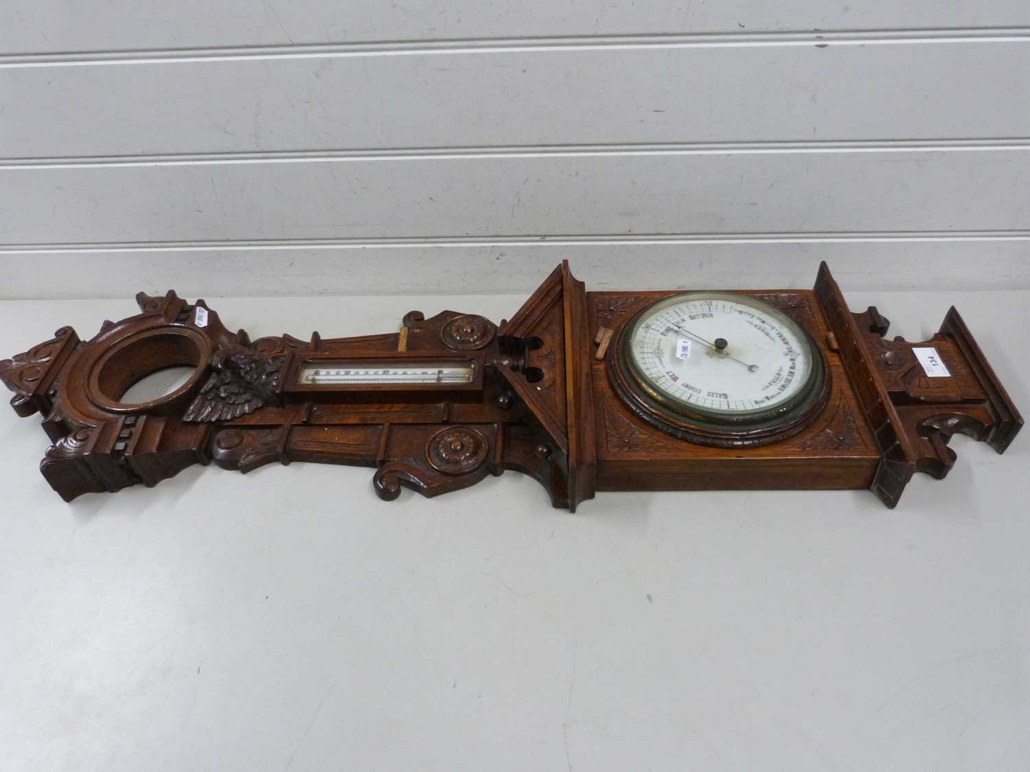 A large and elaborate late 19th Century barometer and thermometer set in a heavily carved case (a/