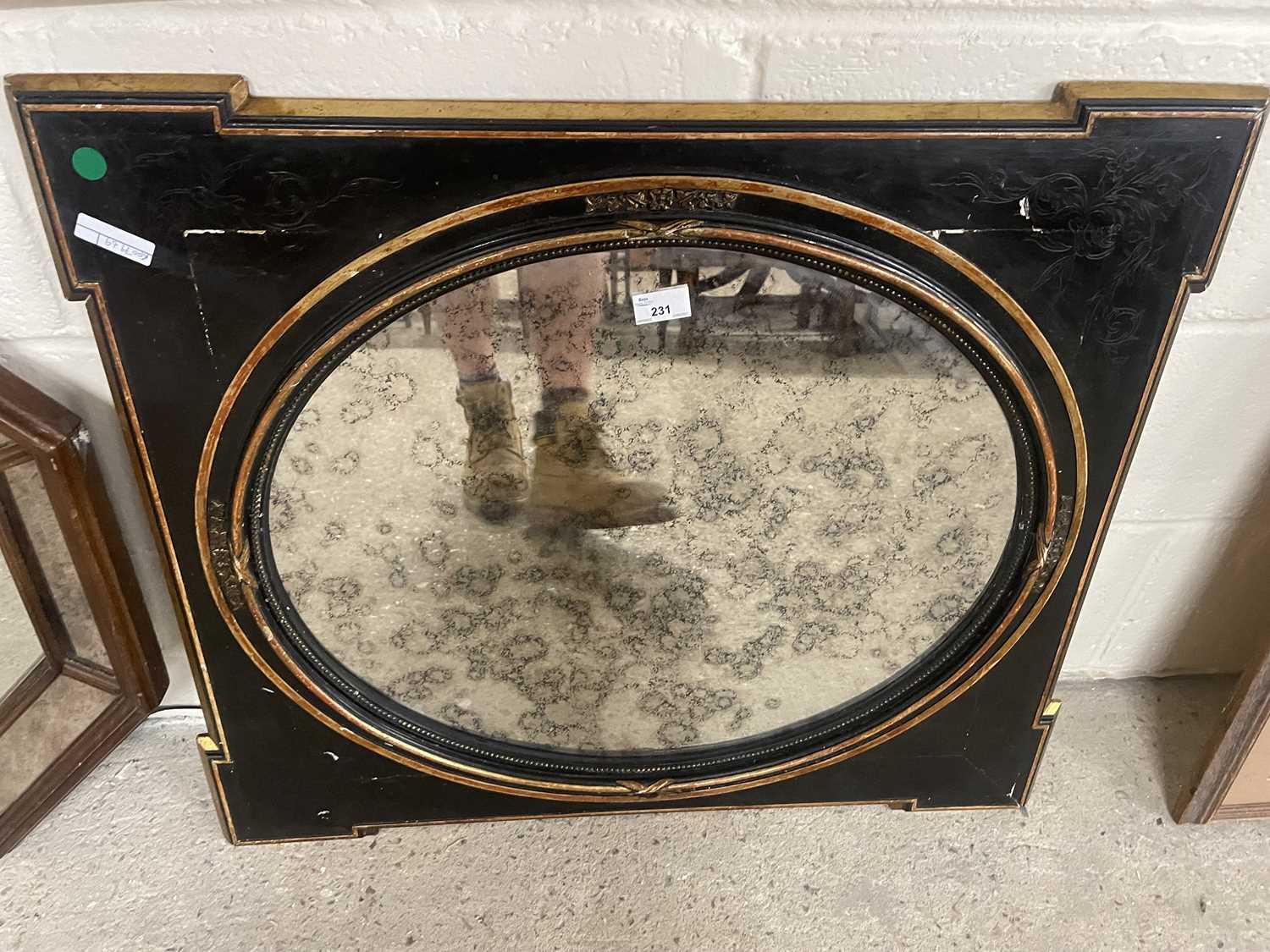 Oval mirror in gilt and black frame and surround