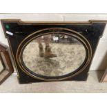 Oval mirror in gilt and black frame and surround