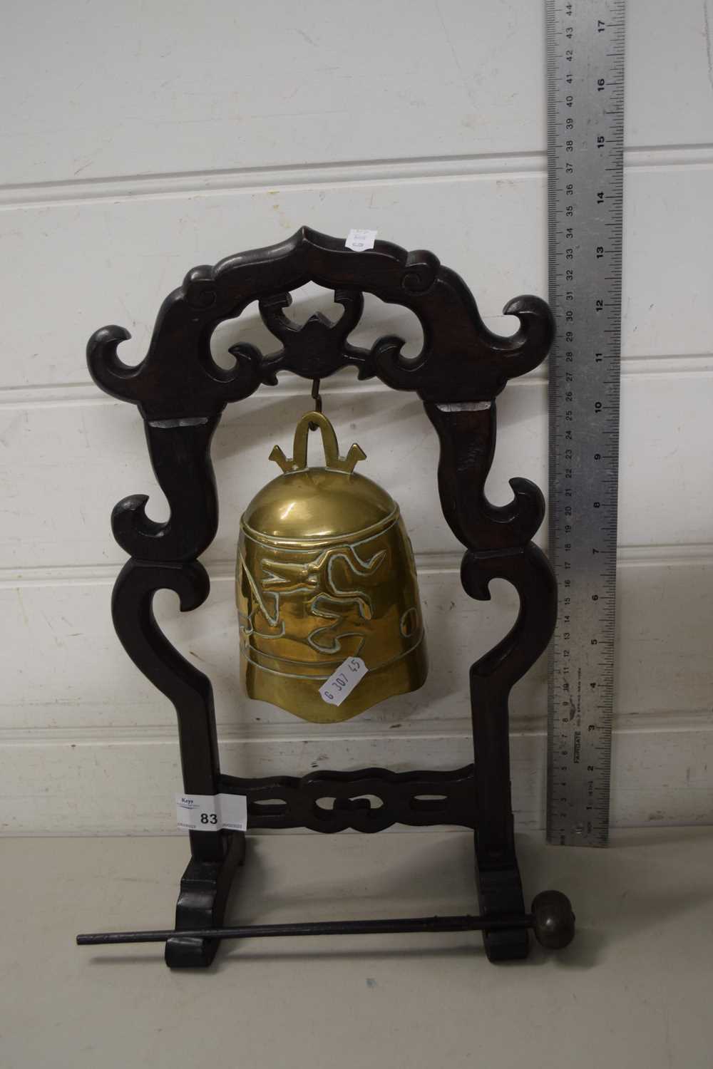 A Chinese brass table bell on hardwood stand