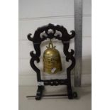 A Chinese brass table bell on hardwood stand