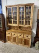 20th Century pine dresser with glazed top section over a base with four drawers and four doors,