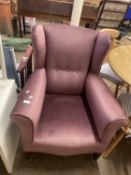 An early 20th Century mauve wingback armchair