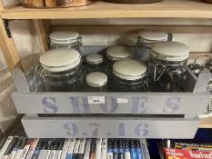 A wooden crate of glass kitchen storage jars