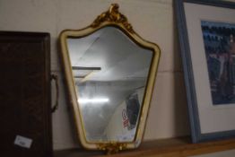 A decorative wall mirror with cream and gilt embossed frame