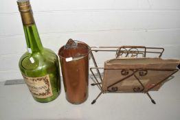 Large empty Cognac bottle together with a magazine rack and a small cylindrical brass jug