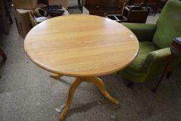 An Ercol light elm circular dining table raised on four footed base, top 100cm diameter