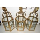 A set of three 20th Century hexagonal brass and glass lantern style light fittings