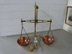 A pair of brass and copper bank scales together with a brass £5 weight