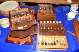 Large collection of various crested and collectors spoons in wall display rack