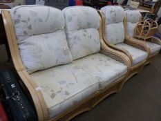 A two seater conservatory sofa together with a pair of matching armchairs