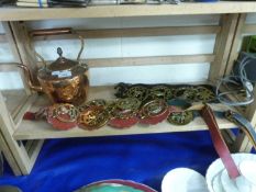 A copper kettle and a selection of various horse brasses