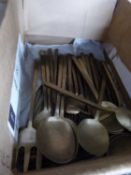 A box of various brass cutlery