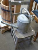A child's pine chair and a watering can