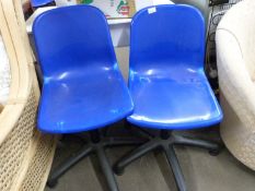 A pair of blue plastic swivel office chairs