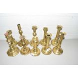 Collection of various antique brass candlesticks to include Ejector examples