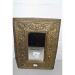 A small rectangular wall mirror in pressed brass foliate decorated frame