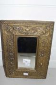 A small rectangular wall mirror in pressed brass foliate decorated frame