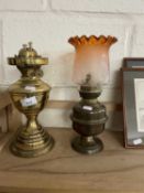 Two brass oil lamps, one with frosted orange shade